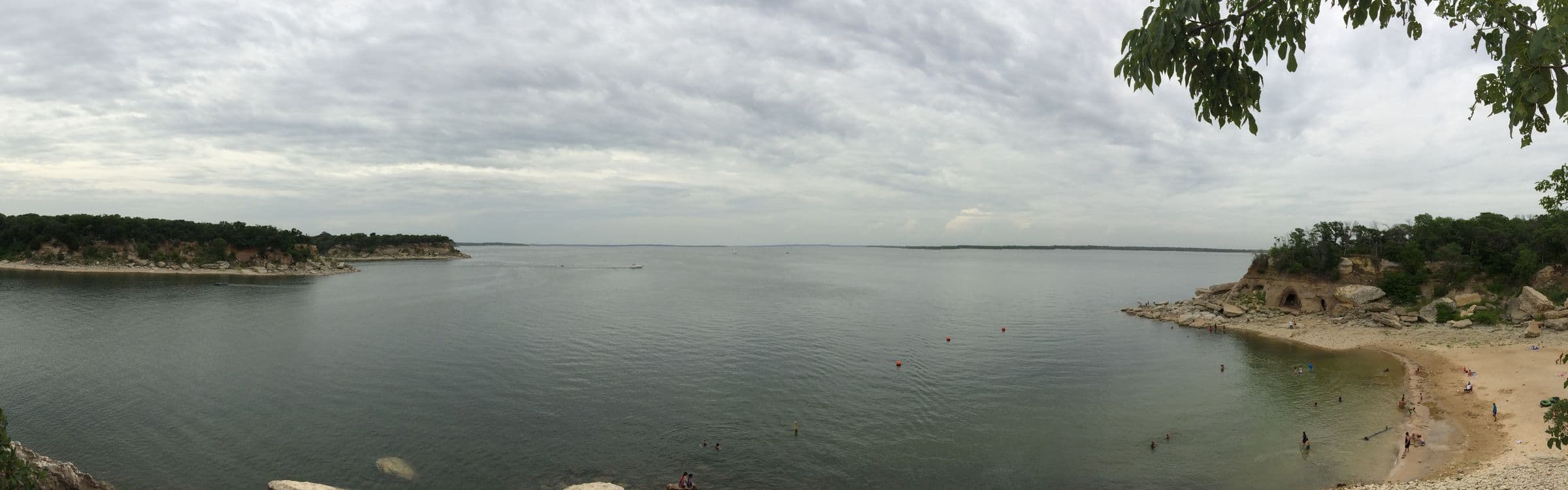 Wide view of Lake Texoma's open water, limestone bluffs and a small beach under a soft gray sky